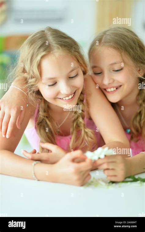 Close Up Portrait Of Cute Twin Sisters With Flower Stock Photo Alamy