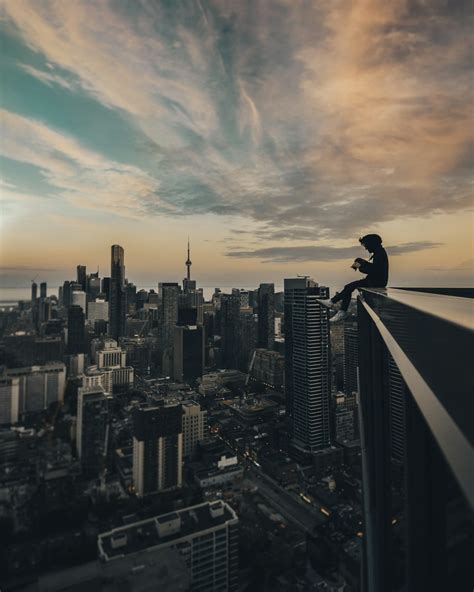 Person Sitting On Top Of The Building Photo Free City Image On Unsplash