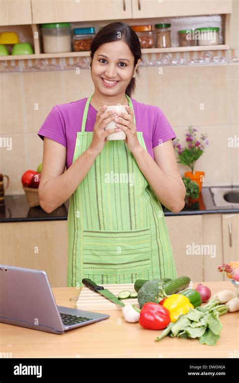 Young Indian Woman Drinking Coffee In Her Kitchen Stock Photo Alamy