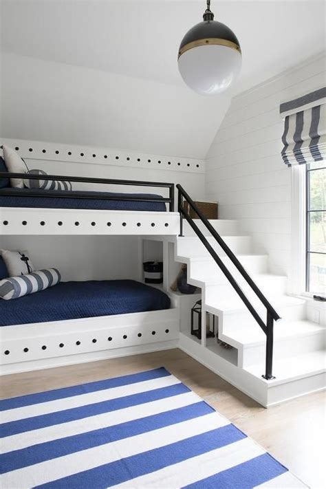 A Nautical Style White Built In Bunk Bed Is Dressed In Blue Bedding