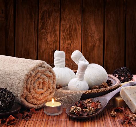 massage die met twee kruidenkompresballen en verse kruiden op witte houten achtergrond