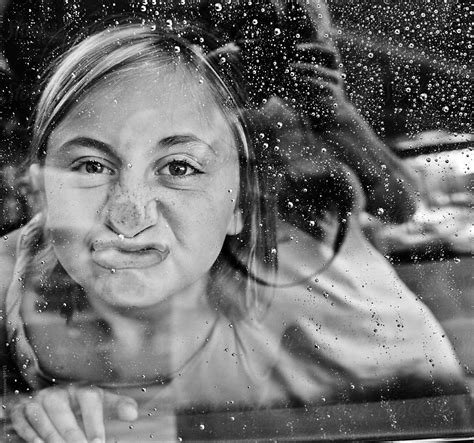 Little Girl Smushing Her Face Against A Rainy Window By Stocksy