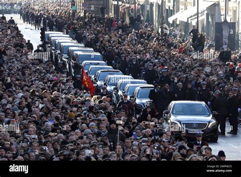 The crowd watch the funeral convoy for French rock star Johnny Hallyday
