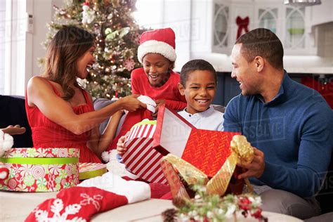 Family opening Christmas presents at home together  Stock Photo  Dissolve