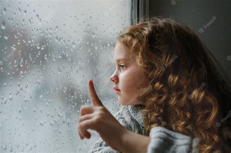 Premium Photo Sad Little Girl Looking Out The Window On Rain Drops