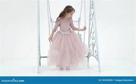 Charming Long Haired Girl In Nice Dress Swinging On Elegant Swing