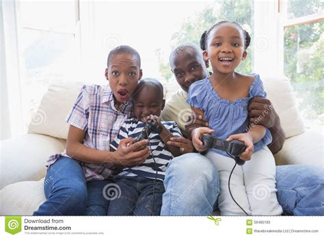Familia Sonriente Feliz Que Juega A Los Videojuegos Juntos Imagen De