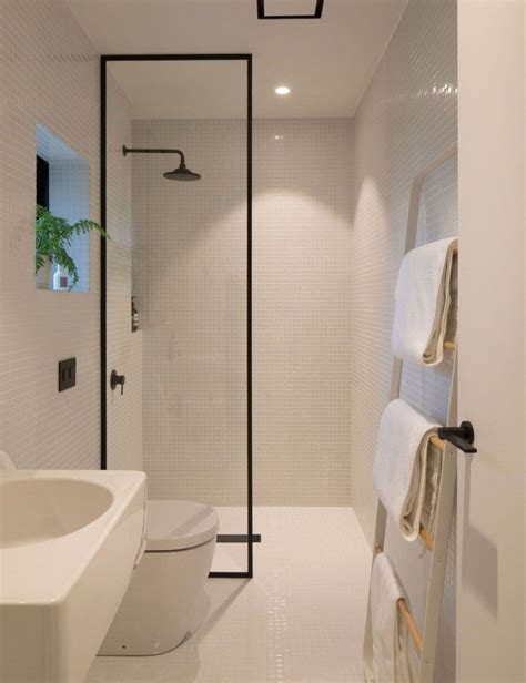 An Instagramted Photo Of A Bathroom With White Tile And Black Accents