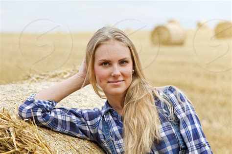 Attractive Blonde Woman Farmer Posing Near Straw Ball On Field By Josef Mohyla Photo Stock
