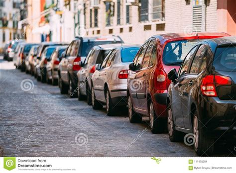Cars Parked On Street In European City In Sunny Summer Day Stock Photo