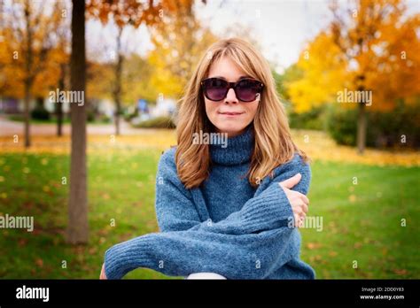 Portrait Shot Of Confident Mature Woman Wearing Turtleneck Sweater And Sunglasses While Standing
