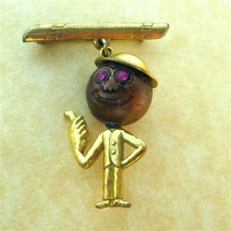 The Charm Depicts A Smiling Man With Top Hat And Pink Gem Eyes His Right Hand Gives The Thumbs