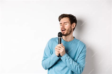 Premium Photo Young Caucasian Man Singing Song In Microphone With Carefree Face Standing In