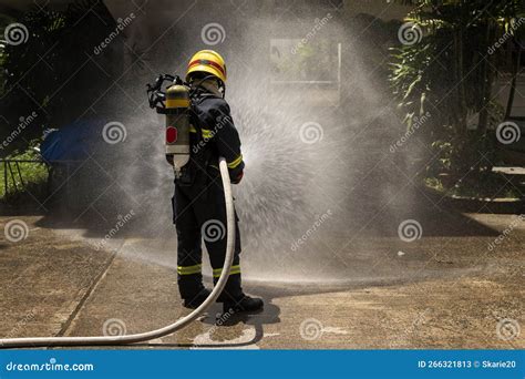 Firefighters With Extinguisher Spraying High Pressure Water To Fighting The Fire Flame In An
