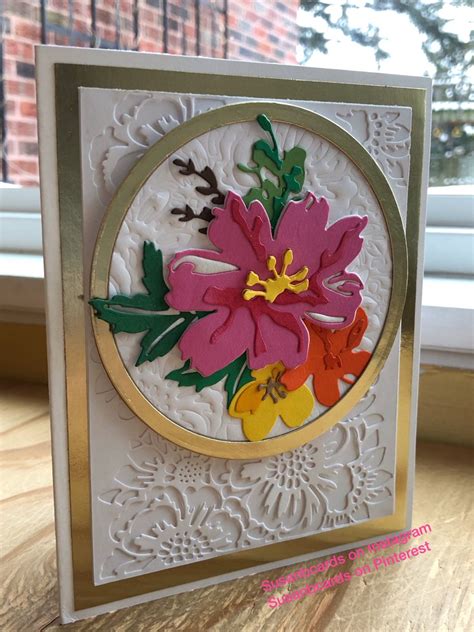 A Close Up Of A Card On A Table Near A Window With Flowers In It