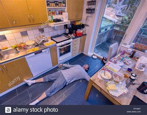 Collapsed Or Flat Out Exhausted Adult Caucasian Man Laying On The Kitchen Floor Surrounded By