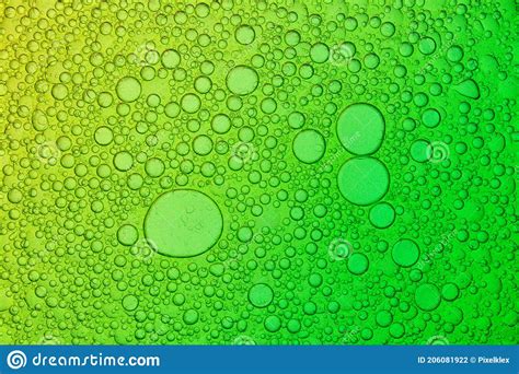 Mixture Of Oil And Water On Yellow And Green Background Stock Photo