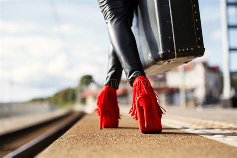 Female With Red High Heels And Suitcase In Train Station Stock Image