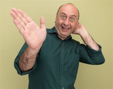 Free Photo Excited Middle Aged Man Wearing Green T Shirt Points With