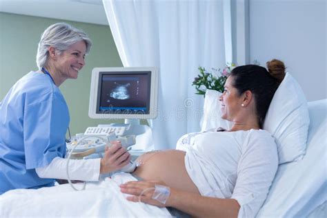 Doctor Doing Ultrasound Scan For Pregnant Woman In The Hospital Stock