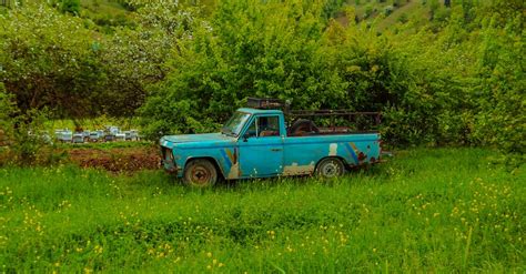 An Old Blue Vehicle Parked On A Green Grass Field · Free Stock Photo