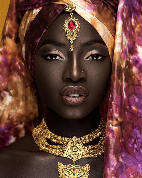 An African Woman Wearing A Gold Necklace And Head Piece