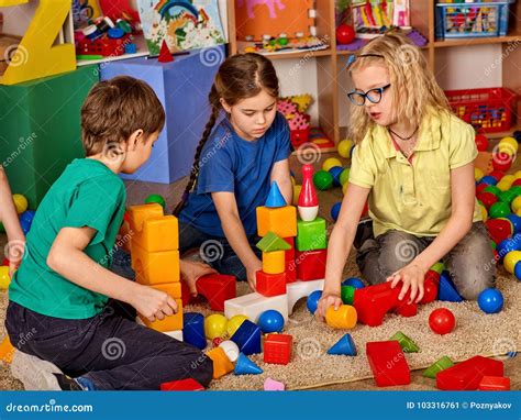 Children Building Blocks In Kindergarten Group Kids Playing Toy Floor