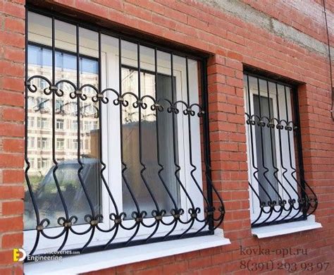 Two Windows With Wrought Iron Bars On The Side Of A Brick Building