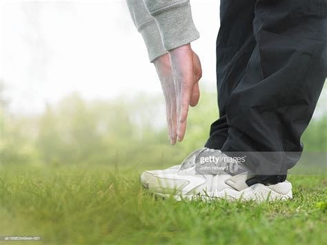 Young Man Doing Exercises On Grass Low Section High Res Stock Photo