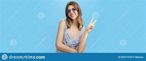 Charming Friendly And Outgoing Young Lady Showing Peace Or Victory