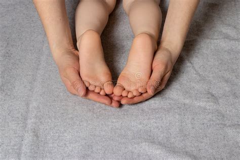Small Children`s Legs Heels In Gentle Affectionate Mother`s Parental
