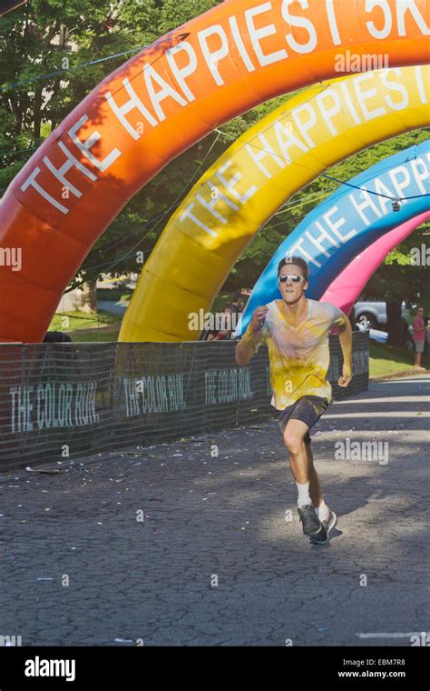 Male Runner Running Fast Splattered With Colorful Dyes Approaches The Finish Line In The The