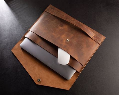 A Leather Bag With A Laptop On It Sitting On Top Of A Black Countertop