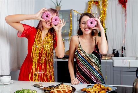 Premium Photo Two Girls Having Fun With Donuts In The Kitchen After A Party