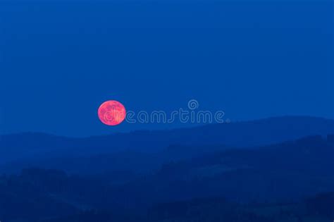 Red Moon Rising From A Mountain Area After Sunset Stock Photo Image