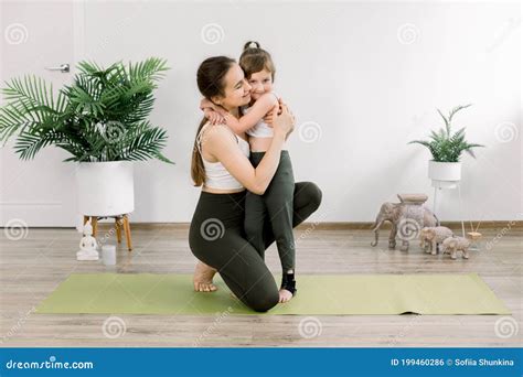 Mother And Daughter Spending Time Together Doing Yoga Exercise Home