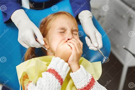 Scared Little Girl Sits At Dentist Chair And Covered Her Mouth From