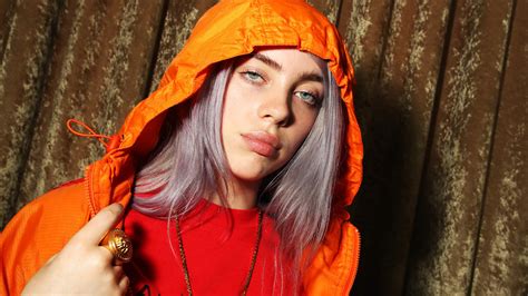 Billie Eilish Is Standing In Front Of Brown Curtain Wearing Red Dress