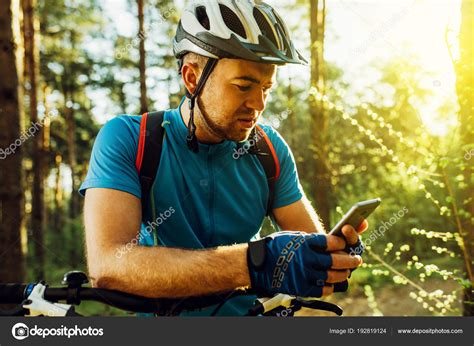 Outdoor Shot Of Concentrated Cyclist On Bike Using Navigator On Smart Phone Explore Map And