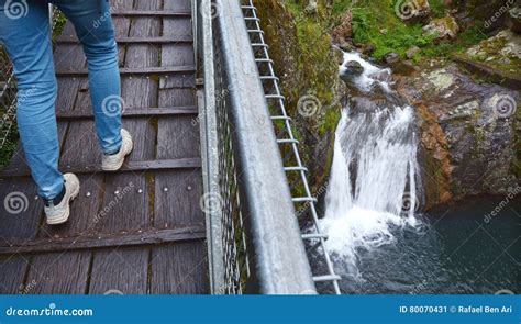 Person Crossing A High Bridge Over A Waterfall Stock Image Image Of