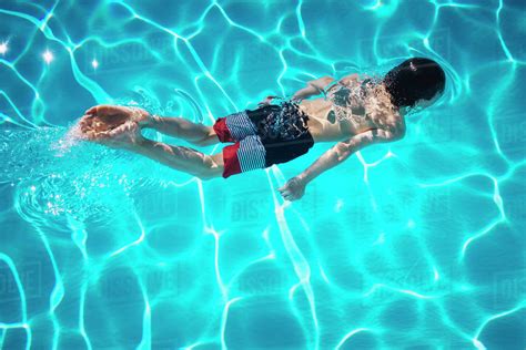 Boy Swimming In Blue Swimming Pool Stock Photo Dissolve