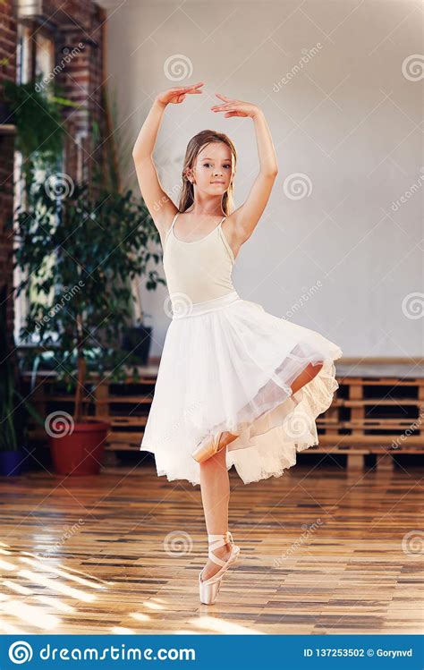 Young Ballerina In White Tutu Practicing Dance Moves Stock Photo