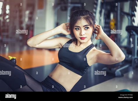 Side View Of Asian Fitness Girl Doing Crunch Twist At Fitness Gym Sports And Workout Concept