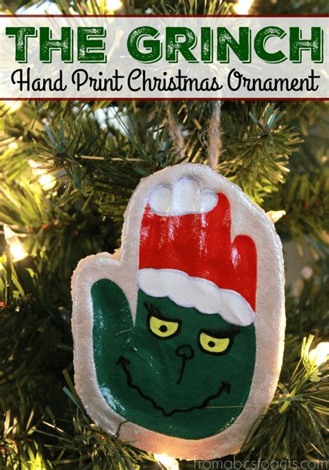 The Grinch Hand Print Christmas Ornament Hanging From A Tree With Text