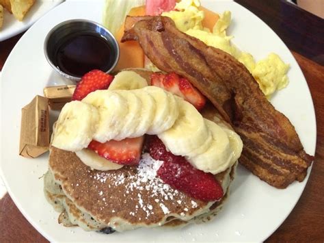 Strawberry And Bananas Over Blueberry Pancakes With A Side Of Scrambled