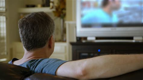 Man Sitting On Couch Watching Tv Turns Stock Footage SBV Storyblocks