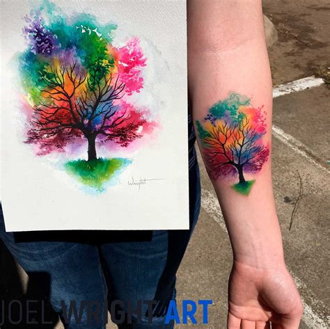 A Person With A Colorful Tree Tattoo On Their Left Arm Holding The