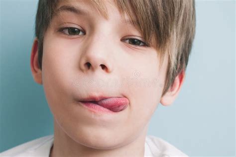 Überzeugter Ruhiger Junge Zeigt Seine Zunge Und Untersucht Kamera Stockfoto Bild Von Bissen
