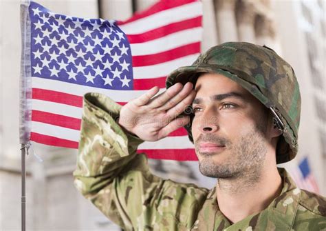 Soldier In Front Of Building With Usa Flag Behind Saluting Stock Image