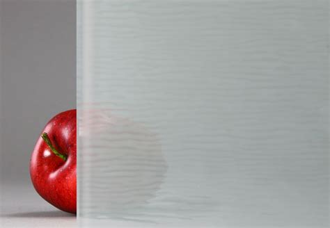 A Red Apple Sitting In Front Of A White Wall With The Reflection Of It S Side